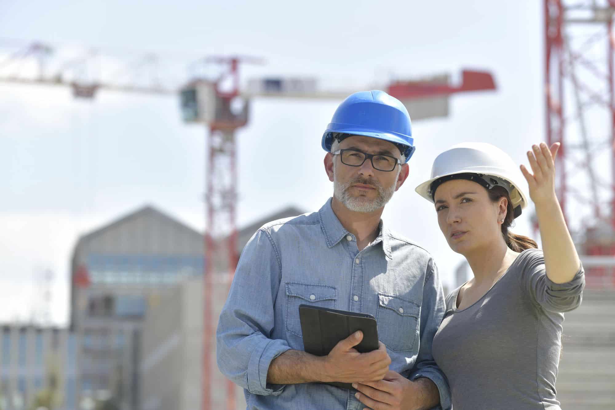 Engenheiros fiscalizando canteiro de obra industrial